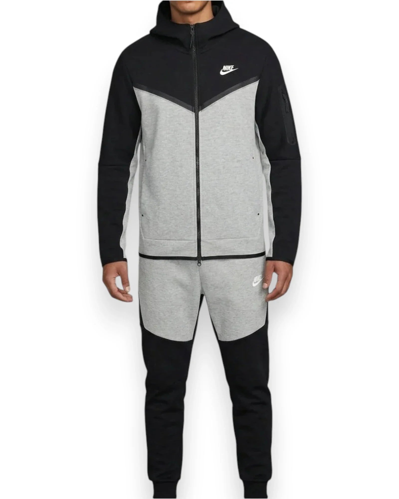 Person wearing a black and gray Nike tracksuit on a white background