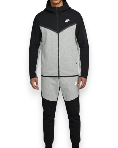 Person wearing a black and gray Nike tracksuit on a white background